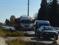 Samochód osobowy, za nim bus, a za busem ciężarówka. wszystkie samochody stoją na jednym pasie jezdni.