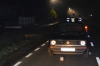 Na jezdni stoi volkswagen, za nim trzej funkcjonariusze straży pożarnej i policji.