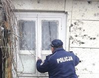 policjant zaglądający przez okno do pustostanu