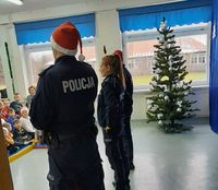 policjanci w mikołajkowych czapkach podczas spotkania z uczniami