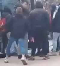 grupa osób wsiadających do autobusu, wśród nich jest agresywny młody mężczyzna, który usiłuje uderzyć drugą osobę