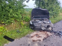 uszkodzony samochód marki Opel koloru ciemnego stojący na poboczu