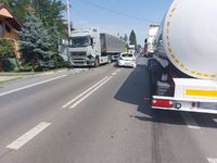 miejsce kolizji drogowej - dwa pojazdy ciężarowe na drodze i stojący pomiędzy nimi samochód osobowy koloru białego