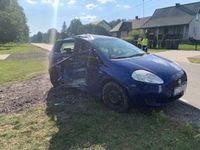 uszkodzony w zdarzeniu drogowym samochód marki Fiat Punto, za pojazdem stojące dwie osoby w kamizelkach odblaskowych