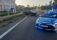 uszkodzone po uderzeniu w barierę ochronną osobowe Audi oraz stojący w poprzek jezdni radiowóz