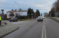 Ulica i przejście dla pieszych, miejsce gdzie doszło do potrącenia dwóch mężczyzn. W bocznej uliczce stoi nieoznakowany radiowóz. Na ulicy stoi Renault, którego kierująca potrąciła osoby piesze.
