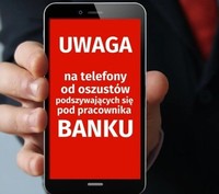 telefon trzymany w ręku, na ekranie widoczne ostrzeżenie przed oszustami podszywającymi się za pracowników banku