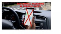 trzymany w dłoni telefon komórkowy przez osobę siedzącą wewnątrz samochodu