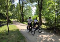 alejką parkową na rowerach jedzie dwóch policjantów