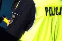 policjant odwrócony tyłem trzyma w ręku alkomat