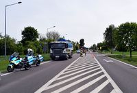 Dwa policyjne motocykle stoją na poboczu drogi, a za nimi stoi pojazd ciężarowy przystosowany do przewozu nieczystości