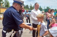 policjant wręcza nagrodę uczestnikowi konkursu