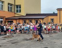 policyjny przewodnik z psem służbowym w czasie pokazu przed dziećmi