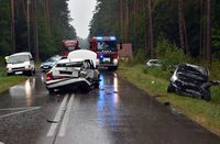 miejsce wypadku rozbite auta stoją na drodze, w tle wóz strażacki i policyjny radiowóz