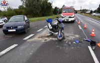 na drodze stoi uszkodzony motorower, obok na drugim pasie ruchu osobowy seat, w tle wóz strażacki