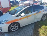 osobowa Toyota z uszkodzonym bokiem, w tle wozy strażackie