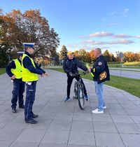 dwaj policjanci, rowerzysta oraz mężczyzna