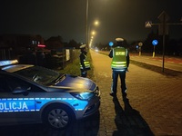 dwóch policjantów obok radiowozu