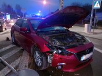 Na drodze na powierzchni wyłączonej z ruchu stoi uszkodzona Mazda obok niej leży znak drogowy