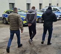 dwaj policjanci w cywilnych ubraniach idą z zatrzymanym