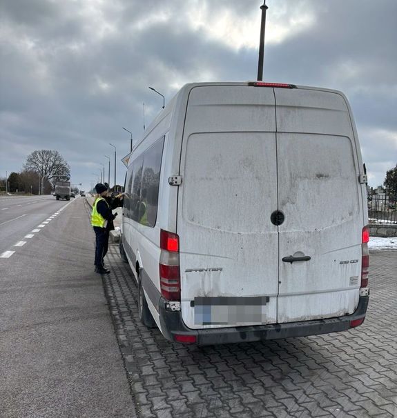 policjant obok drzwi kierowcy busa