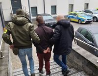 policjanci z zatrzymanym w czasie doprowadzenia