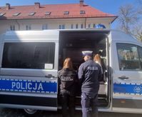 policjant i uczennica klasy policyjnej przy radiowozie