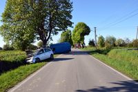 miejsce wypadku drogowego, w przydrożnym rowie stoi osobowy Opel, za nim w drzew wjechał pojazd typu bus marki Renault