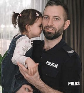 policjant trzymający na rękach córkę