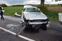 na jezdni stoi uszkodzony w wyniku zderzenia z Kia osobowe Audi, podchodzi do niego policjantka