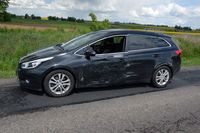 na poboczu drogi stoi uszkodzone w wyniku zderzenia z Audi osobowe Kia
