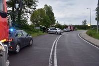 łuk drogi, na poboczu stoją pojazdy służb ratunkowych oraz dwa osobowe samochody uszkodzone w wyniku zderzenia