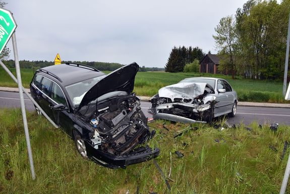 osobowy volkswagen stoi częściowo w przydrożnym rowie obok niego na jezdni BMW, oba uszkodzone po zderzeniu