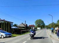 policjant na motocyklu służbowym, na poboczu stoi radiowóz