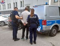 zatrzymany doprowadzany przez dwoje policjantów