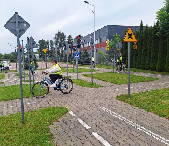 miasteczko ruchu drogowego i jeżdżący po uliczkach na rowerach uczniowie