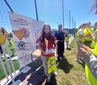 laureatka konkursu, w tle policjant