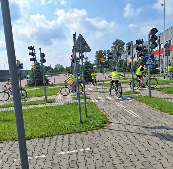 uczniowie na rowerach jeżdżą uliczkami miasteczka rowerowego w czasie egzaminu na kartę rowerową