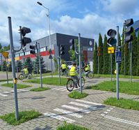 uczniowie na rowerach jeżdżą uliczkami miasteczka rowerowego w czasie egzaminu na kartę rowerową