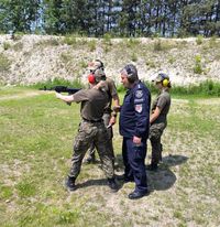 policjant i inny instruktor podczas strzelania przez kursanta