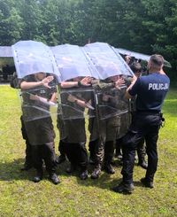 policjant uczy młodzież tworzenia tyraliery