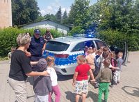 policjant pokazuje dzieciom radiowóz