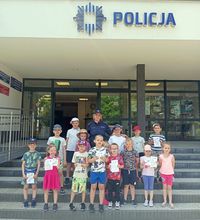 policjantka z dziećmi przed budynkiem komendy