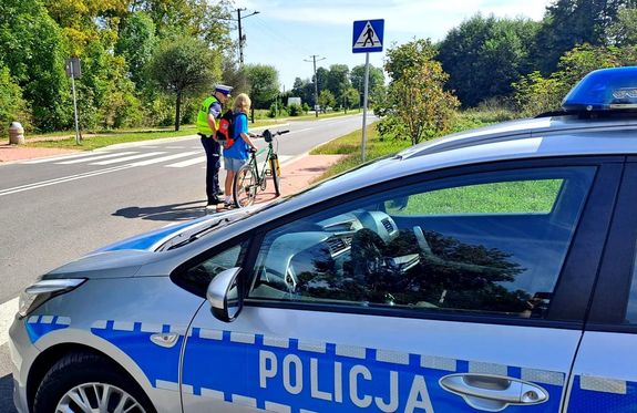 policjant i rowerzysta obok radiowozu
