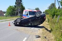 na drodze na dachu leży osobowa Skoda, w tle karetka pogotowia