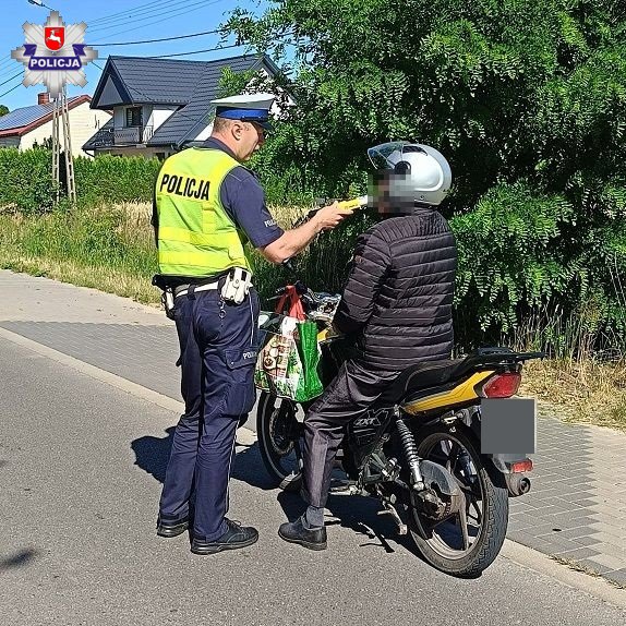 policjant alkomatem bada trzeźwość kierującego skuterem