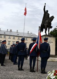 poczet sztandarowy, w tle pomnik Jana Zamoyskiego