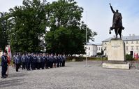 pododdział mianowanych policjantów, w tle pomnik Jana Zamoyskiego jadącego na koniu