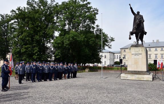 pododdział mianowanych policjantów, w tle pomnik Jana Zamoyskiego jadącego na koniu