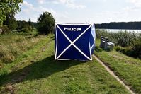 rozłożony na grobli przy zalewie parawan z napisem Policja